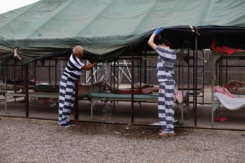 Vězni vylévají po dešti vodu ze střech stanů, do kterých je Arpaio nastěhoval.
