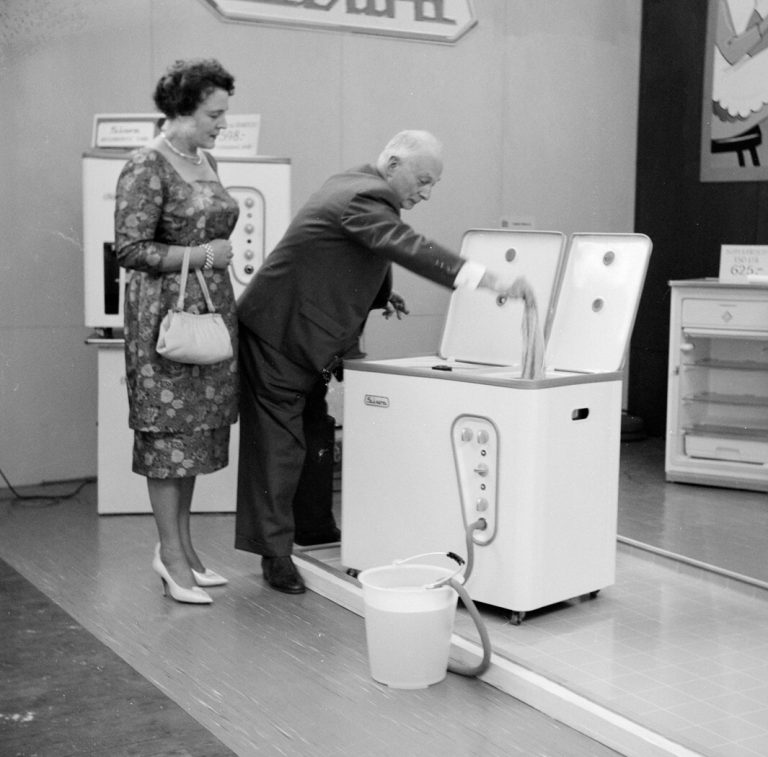 Výstava domácích spotřebičů v Nizozemsku v roce 1960. Elektrické pračky už mají řadu užitečných funkcí.