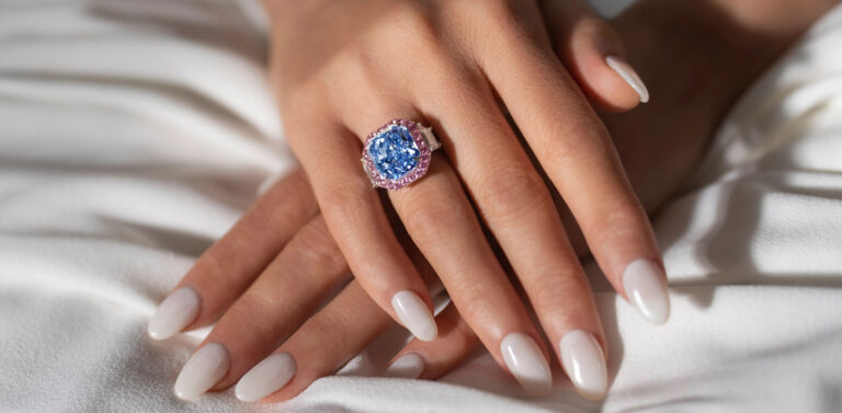 Kámen Infinite Blue je vsazený do diamantového prstenu a obklopují jej růžové brilianty.